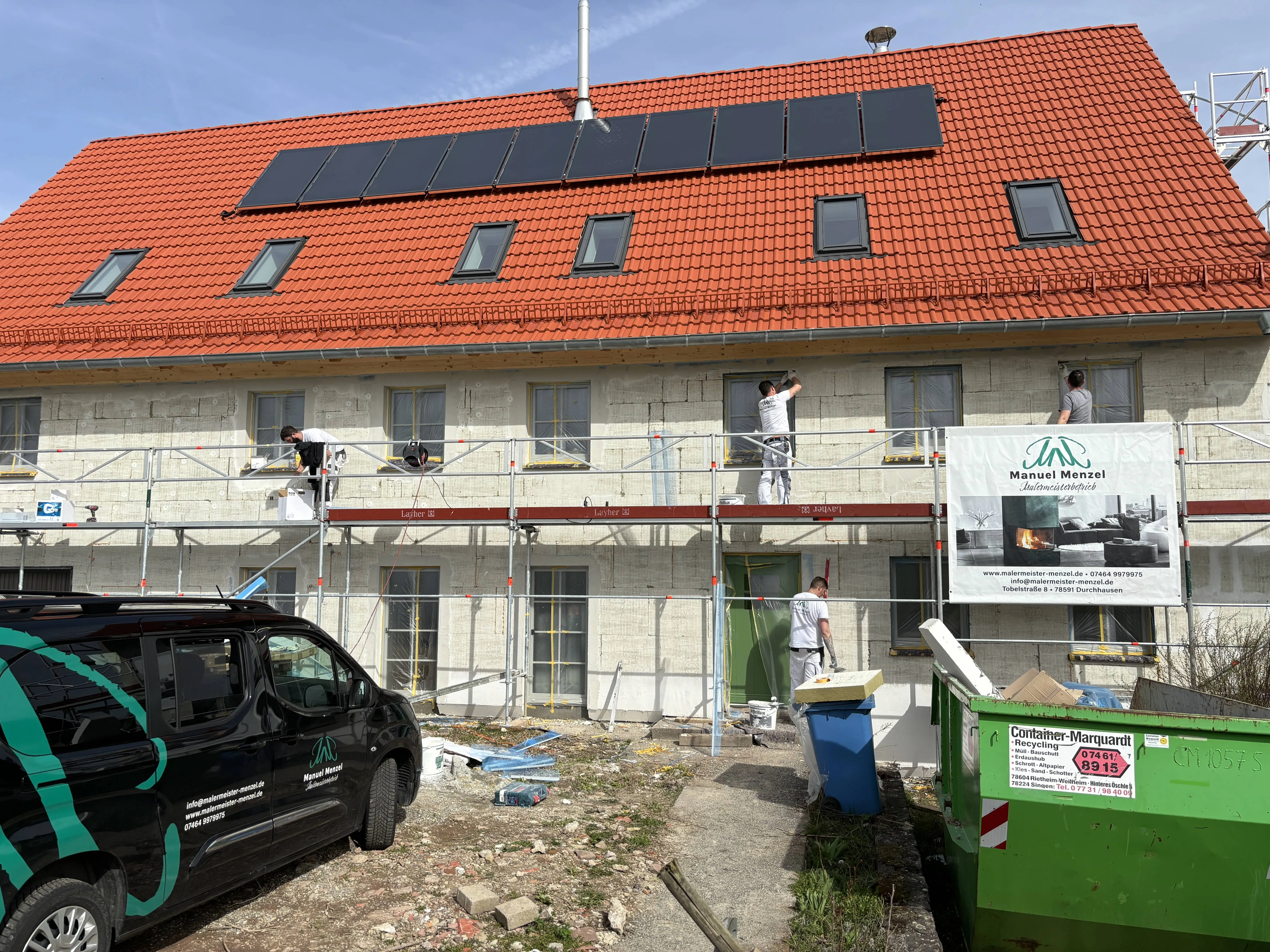 Wohnhaus mit Solaranlage und Baustellenbanner von Malermeister Menzel